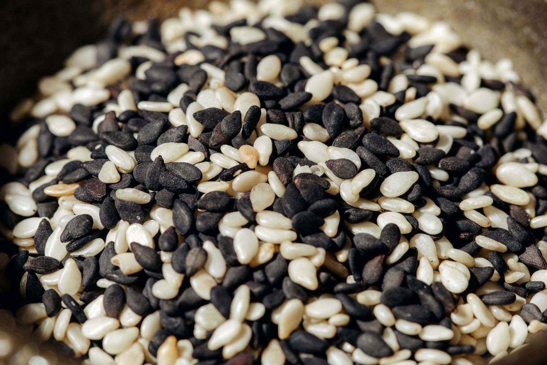 kalonji price in pakistan – A high-resolution close-up photo of mixed black and white sesame seeds, showcasing texture and detail.