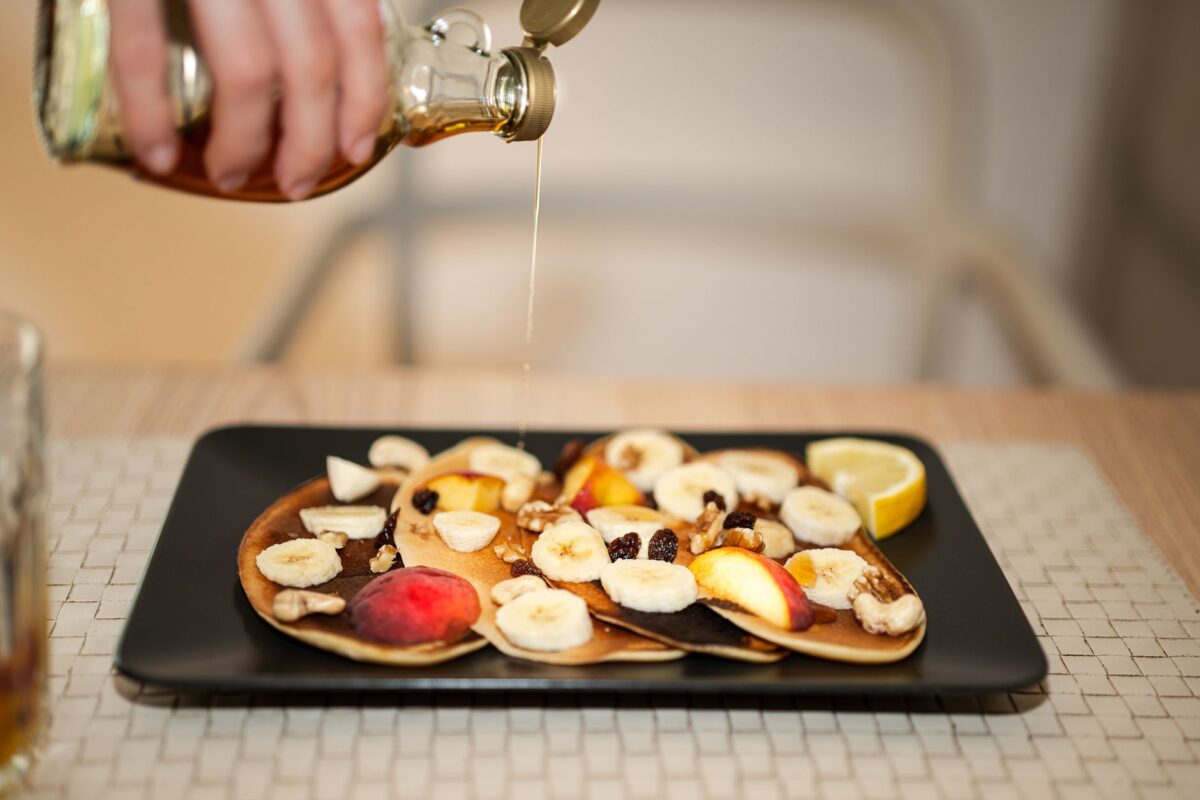 Indulge in a tasty stack of pancakes topped with fresh fruit and syrup, perfect for breakfast, related to Shilajit Honey Syrup for immunity