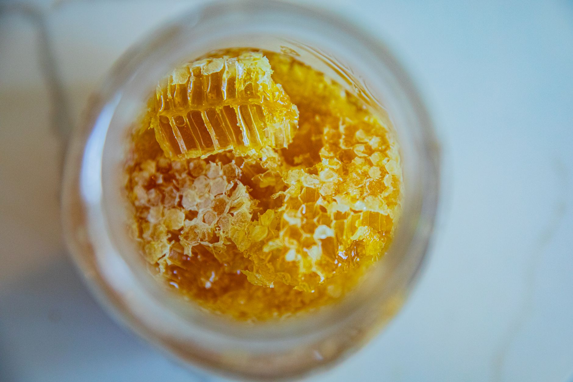 Shilajit honey syrup for skin benefits – Close-up view of fresh honeycomb pieces in a jar, showcasing natural sweetness and texture.