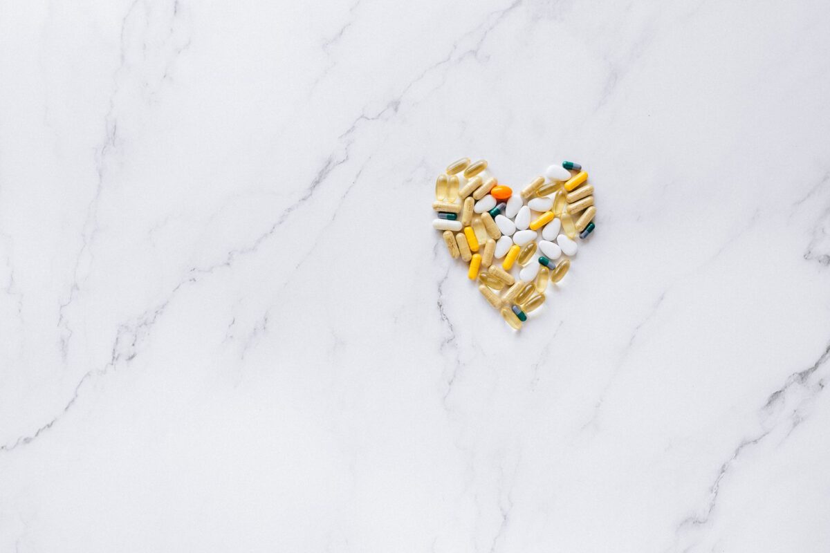 Colorful pills arranged in a heart shape on a marble surface, symbolizing healthcare and well-being — Shilajit honey syrup heart health benefits